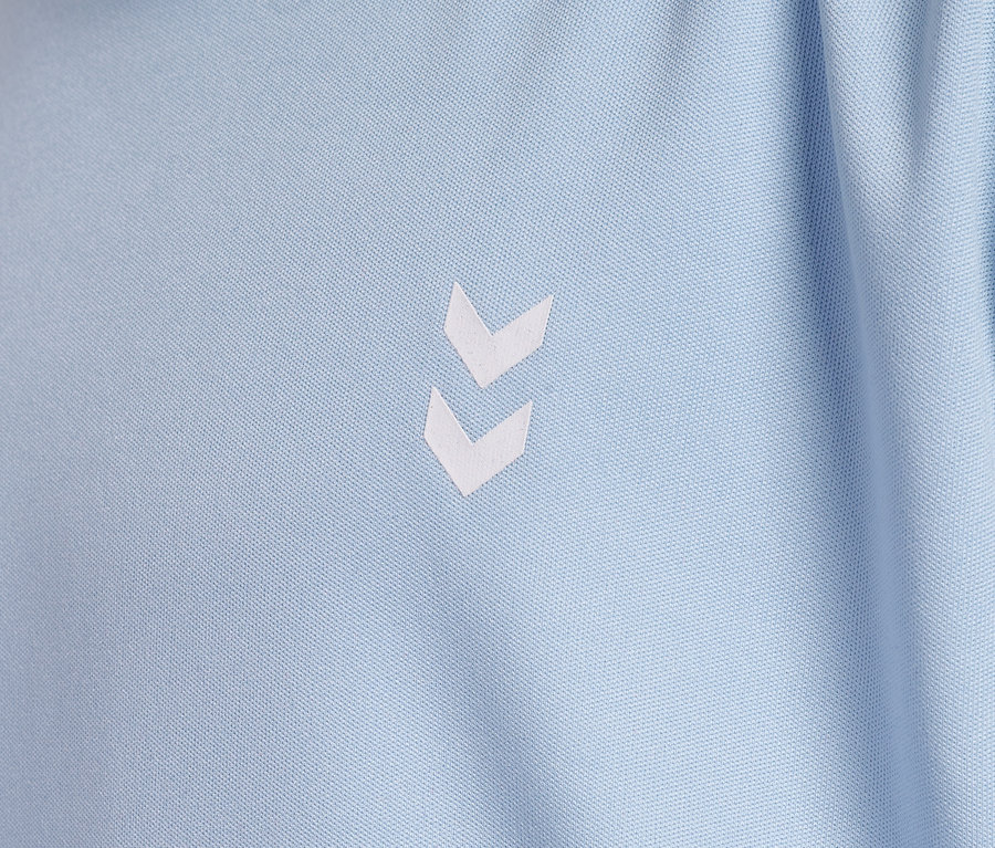 Gros plan sur un t-shirt d'entraînement HUMMEL HMLJR pulse bleu clair avec un logo blanc.
