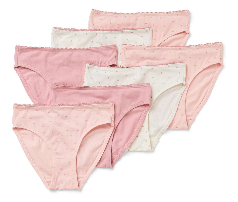 Un ensemble de sept slips pour femmes dans différentes nuances de rose et de blanc avec des pois, empilés les uns sur les autres.