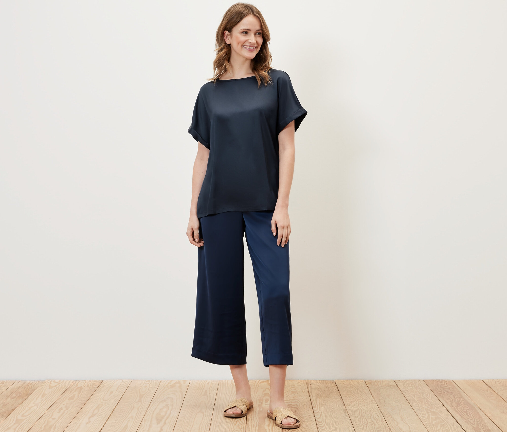 Femme portant une blouse bimatière bleu marine et un pantalon bleu.