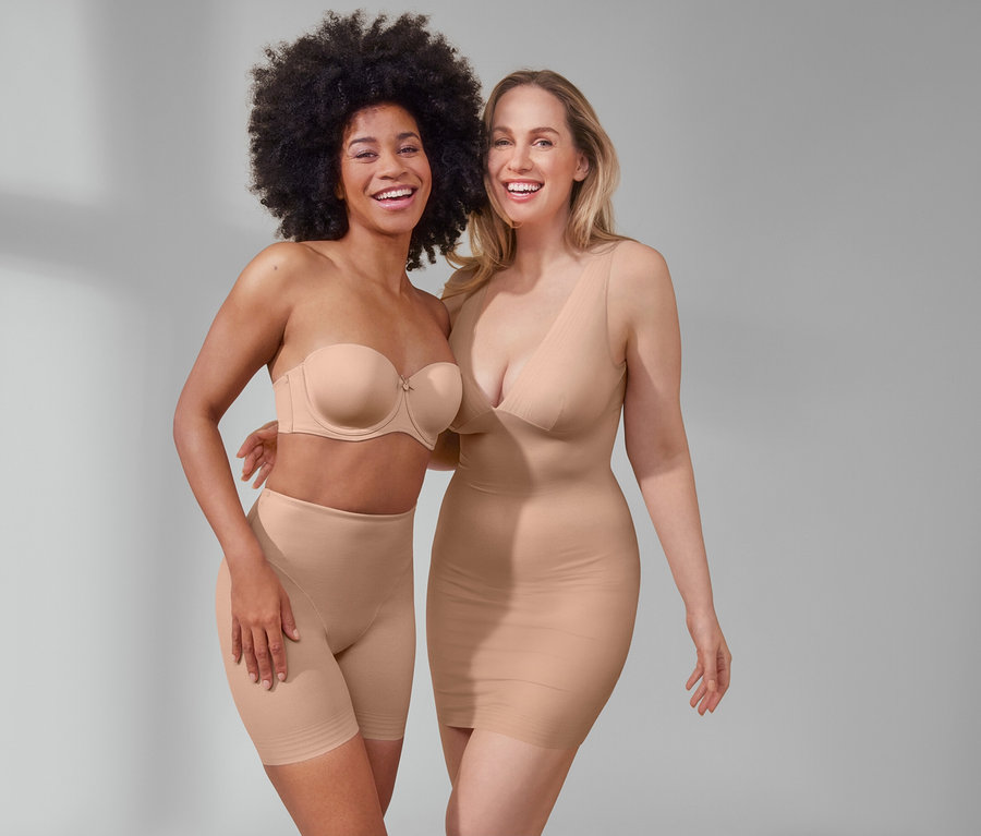 Deux femmes souriantes posent. L'une porte un soutien-gorge multiposition et un short « Shaping » beige. L'autre porte une sous-robe « Shaping » beige.