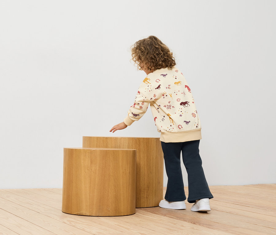 Une fille regarde deux tabourets en bois