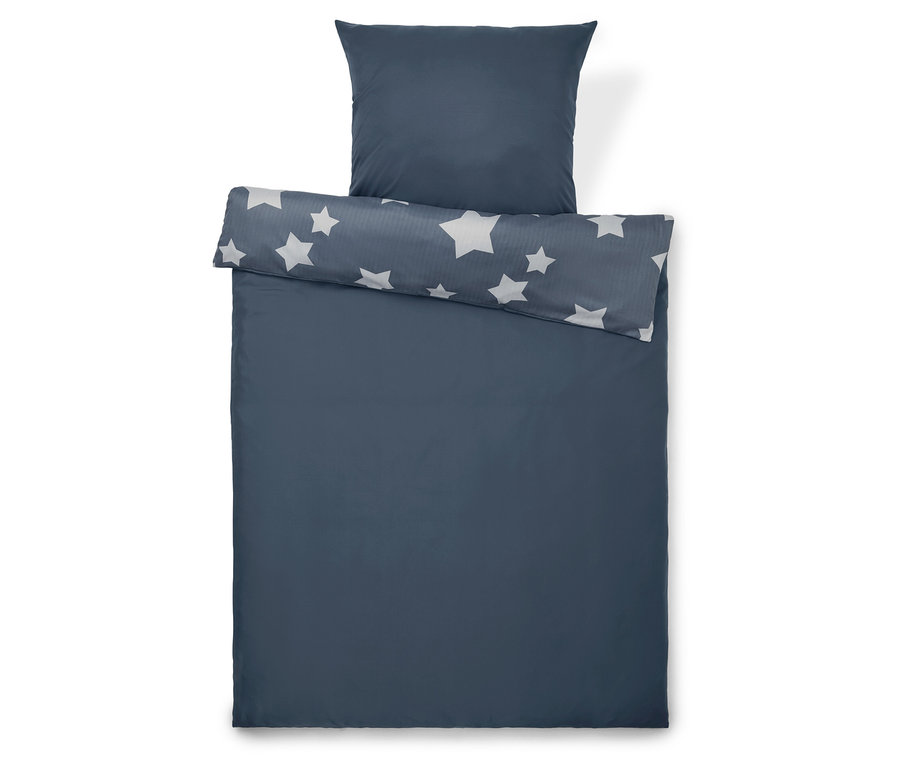 Ensemble de literie bleu avec des étoiles et un oreiller.