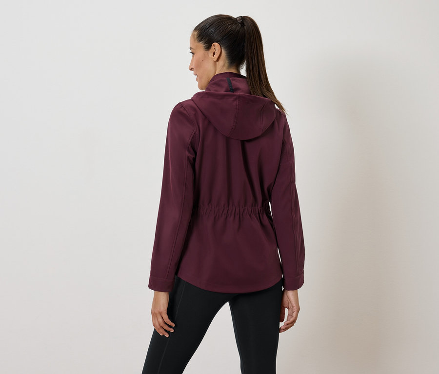 Femme portant un pull en polaire bordeaux à capuche et un legging noir, vue de dos.