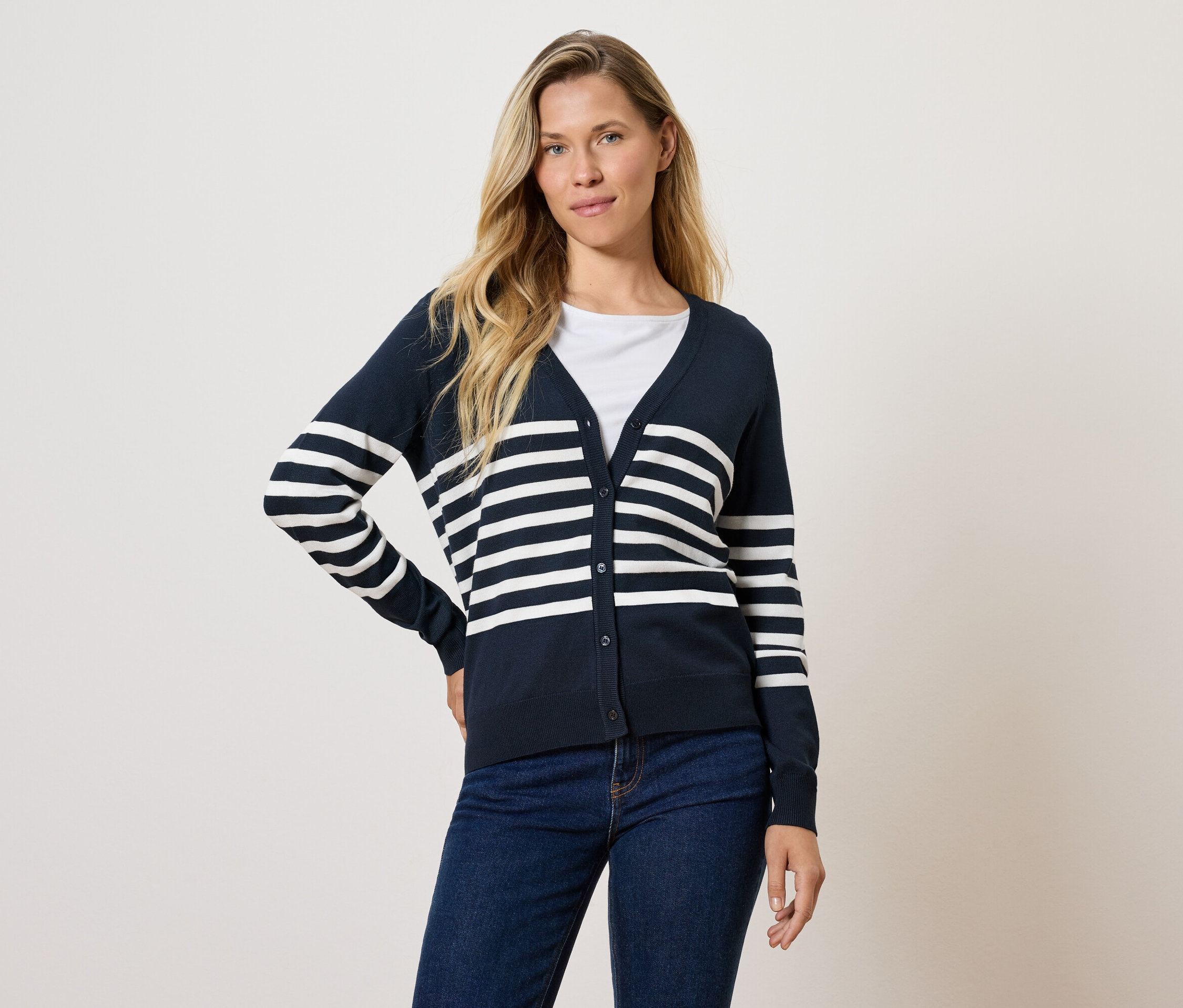 Femme posant en cardigan rayé marine et jean.