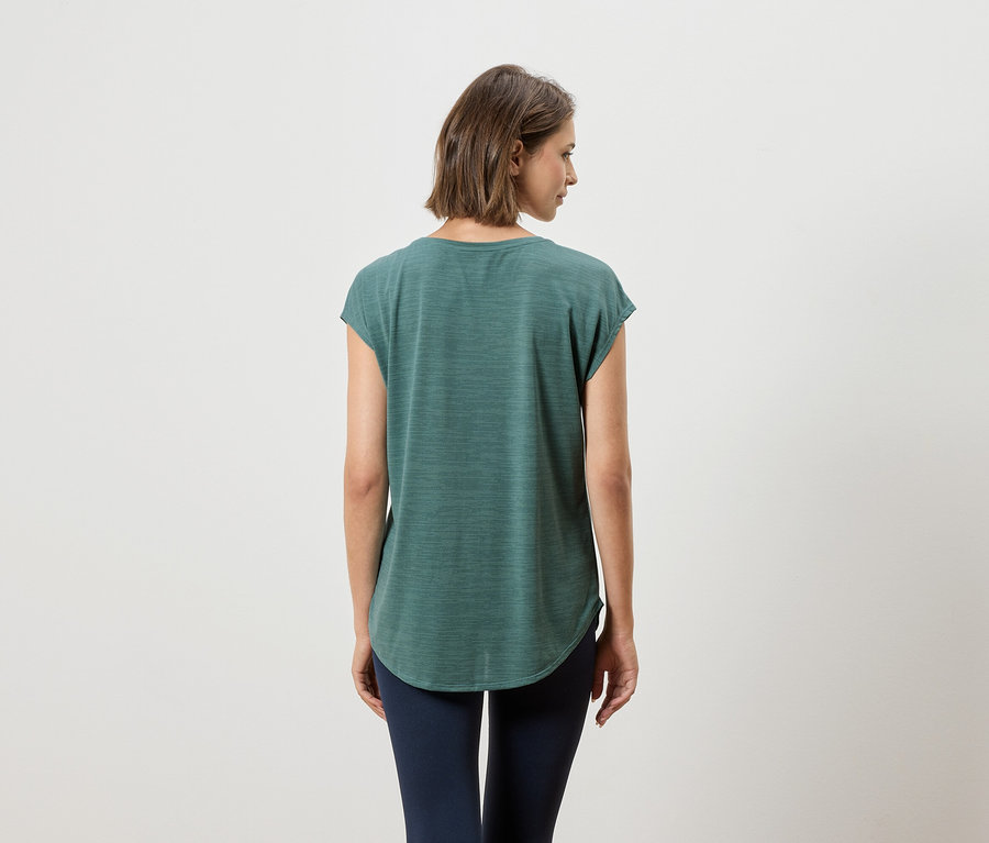 Vue de dos d'une femme aux cheveux courts bruns portant un t-shirt vert et un legging bleu marine.