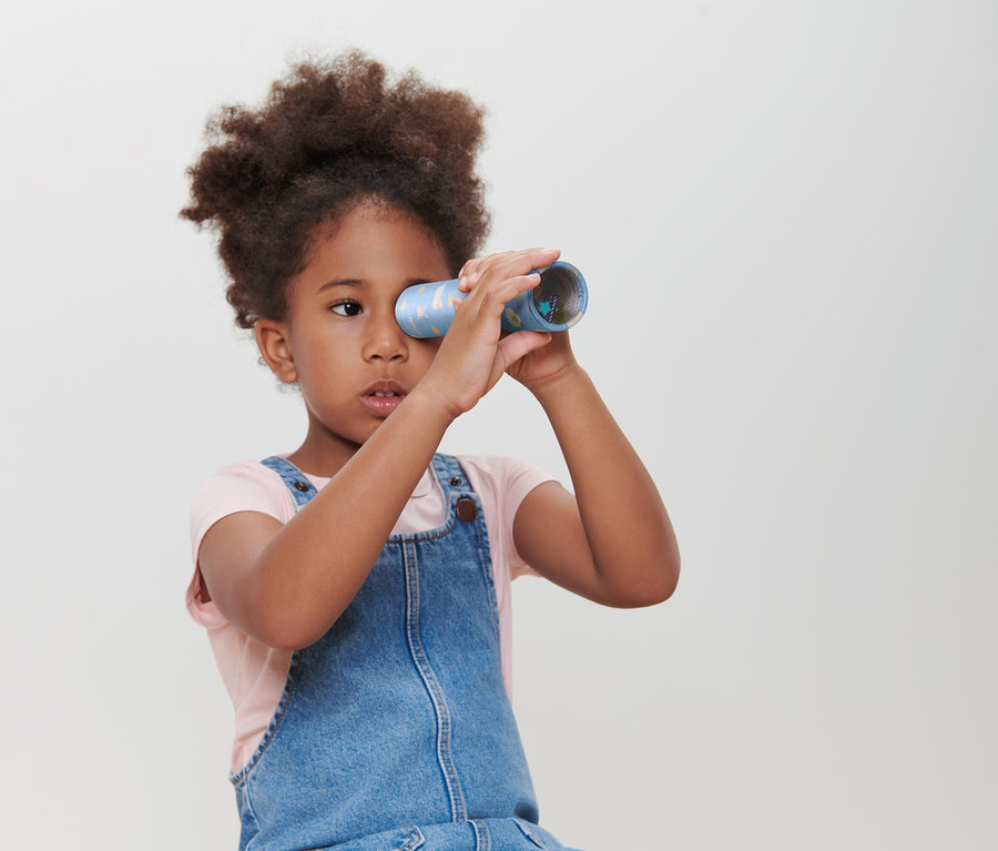 Une fille regarde à travers un caléidoscope.