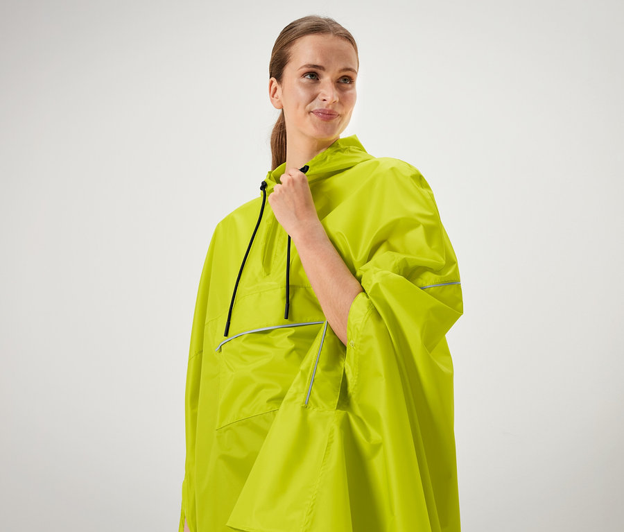 Femme tenant le col d'un poncho vert néon.