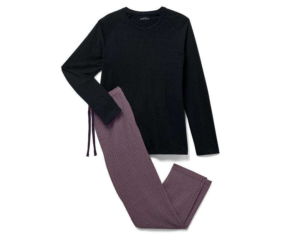 Un t-shirt noir à manches longues et un pantalon à motifs sont posés sur un fond blanc.