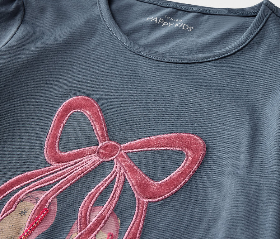 T-shirt bleu à manches courtes avec application de chaussons de ballet avec un ruban rose.