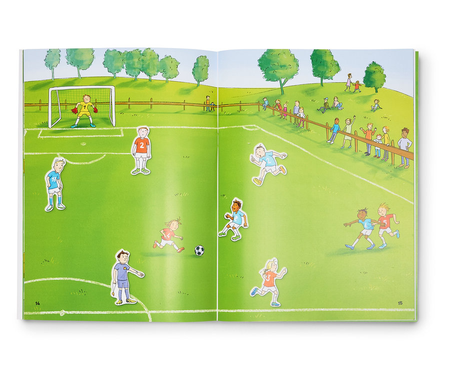 Un livre ouvert montre une illustration d'un match de football avec des joueurs, un gardien de but, un ballon et des spectateurs.