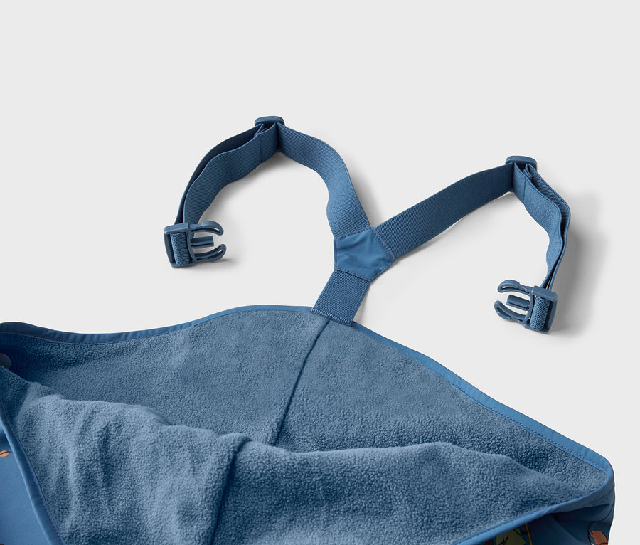 Gros plan sur un poncho de bain bleu avec capuche et bretelles réglables avec boucles.
