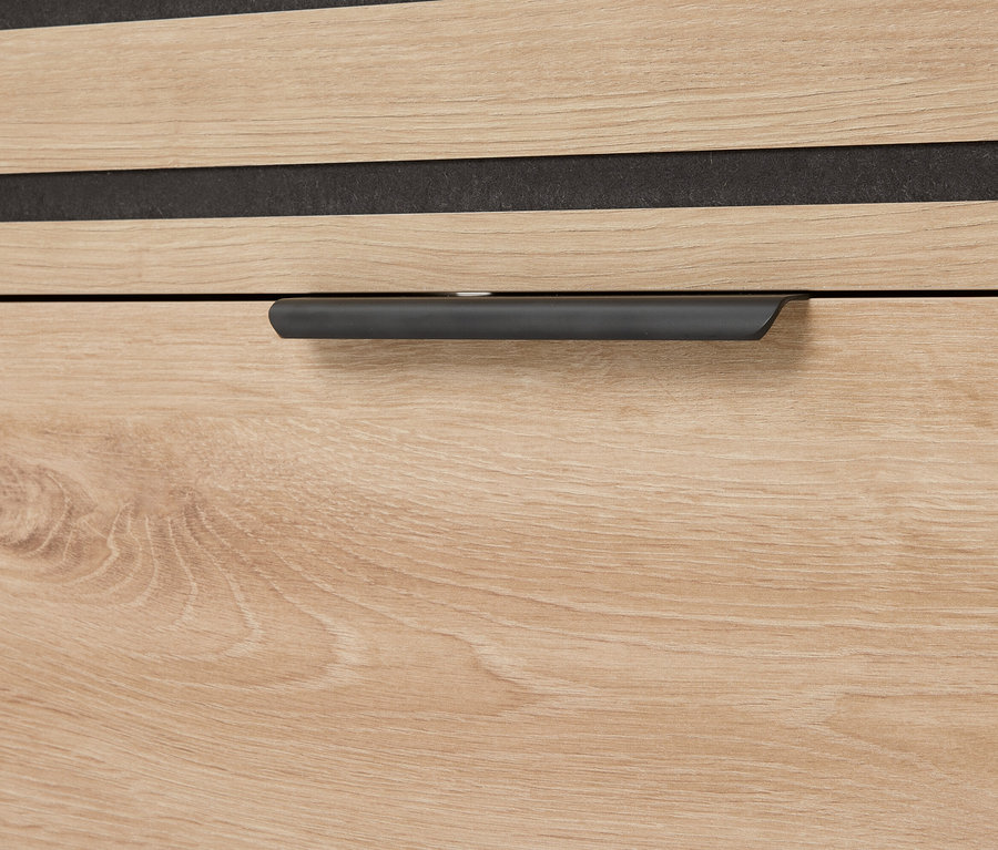 Gros plan d'un tiroir avec un grain de bois et une poignée grise.