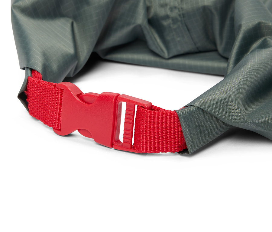 Gros plan d'un sac étanche gris avec une fermeture rouge.