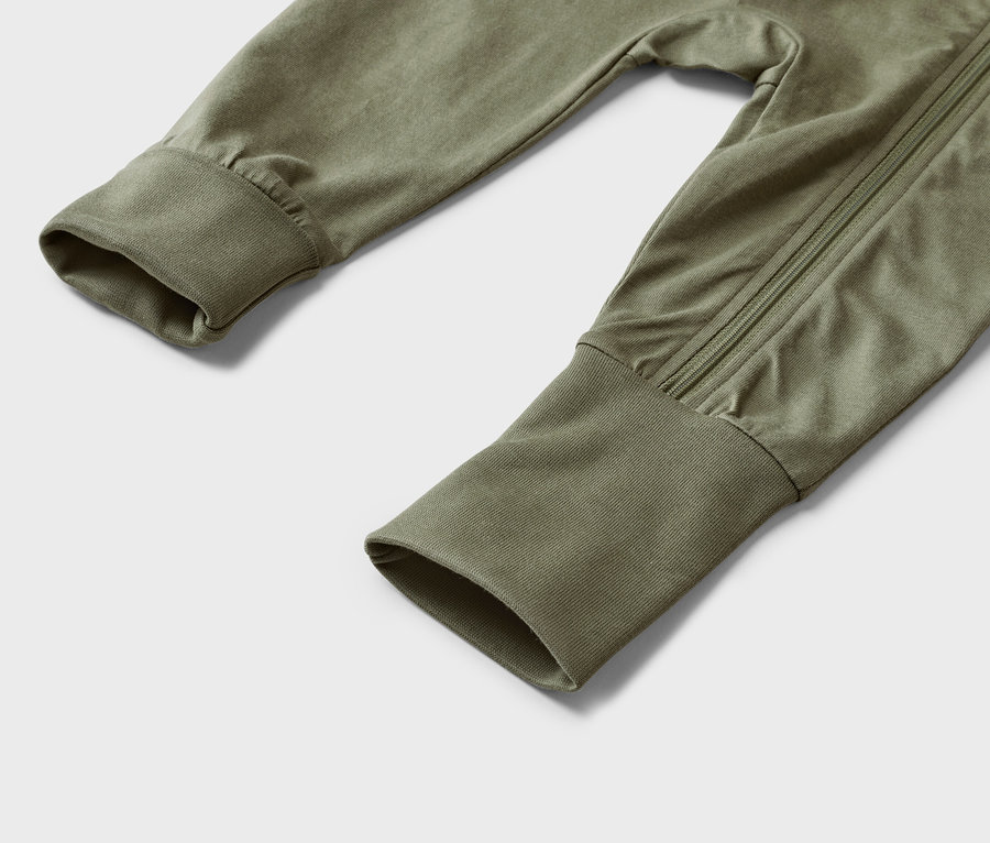 Gros plan d'une grenouillère vert olive pour bébé avec des manches longues et des poignets.