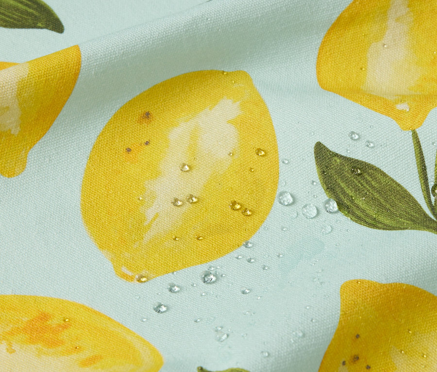 Gros plan d'un tissu bleu clair avec un motif de citrons et des gouttes d'eau.