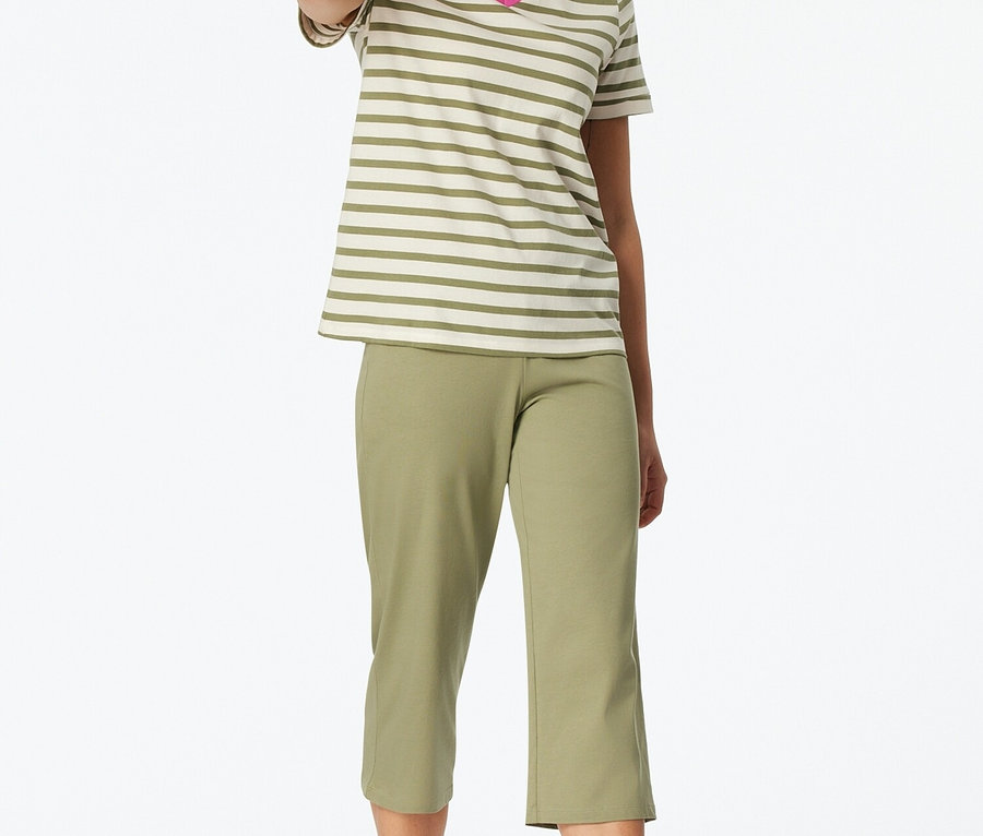 Femme debout pieds nus portant un t-shirt rayé à col en V et un pantalon capri vert.