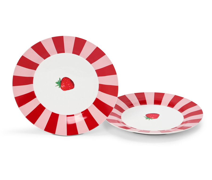 Deux assiettes avec des rayures rouges et roses et une fraise au milieu.