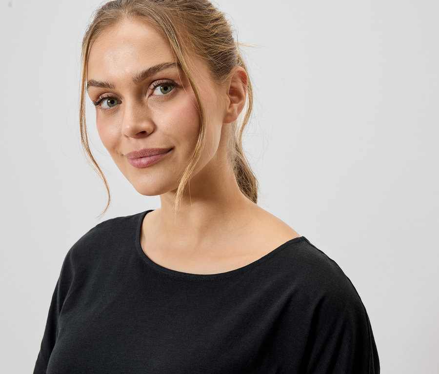 Portrait d'une femme aux cheveux blonds portant un t-shirt noir.