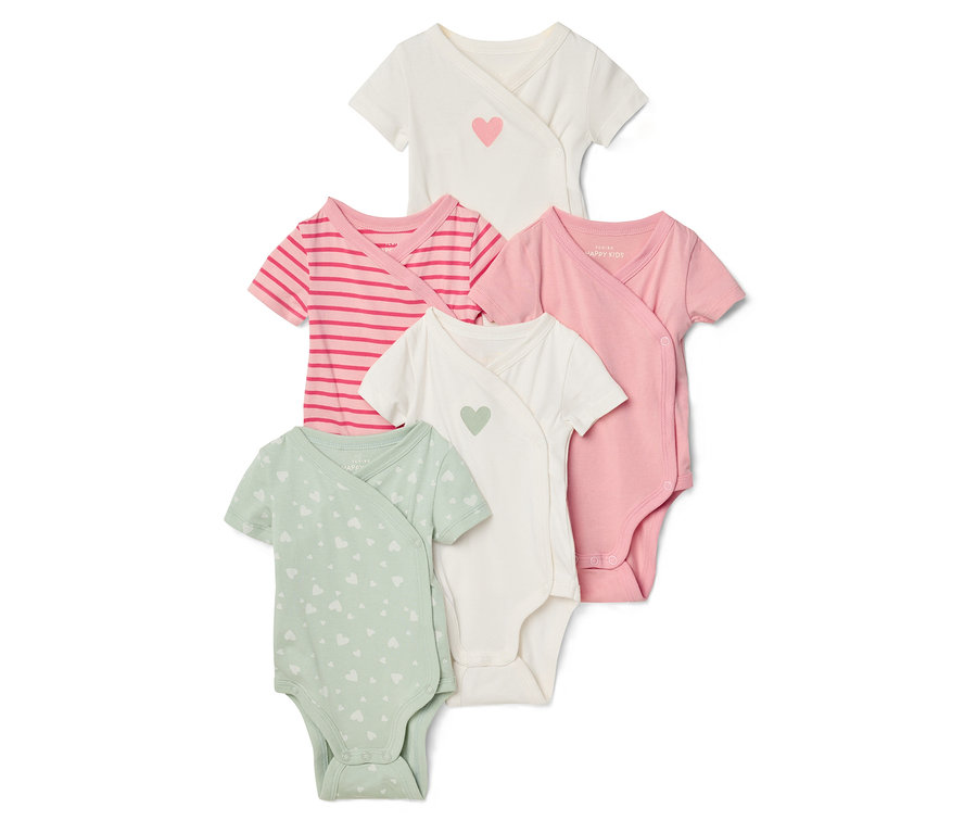 Cinq cache-couches à manches courtes pour bébé, blanc avec cœur rose, rayé rose, rose uni et vert avec cœurs blancs, sont superposés.