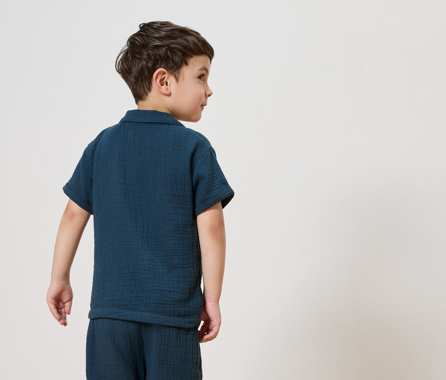 Un garçon portant un pyjama bleu marine.