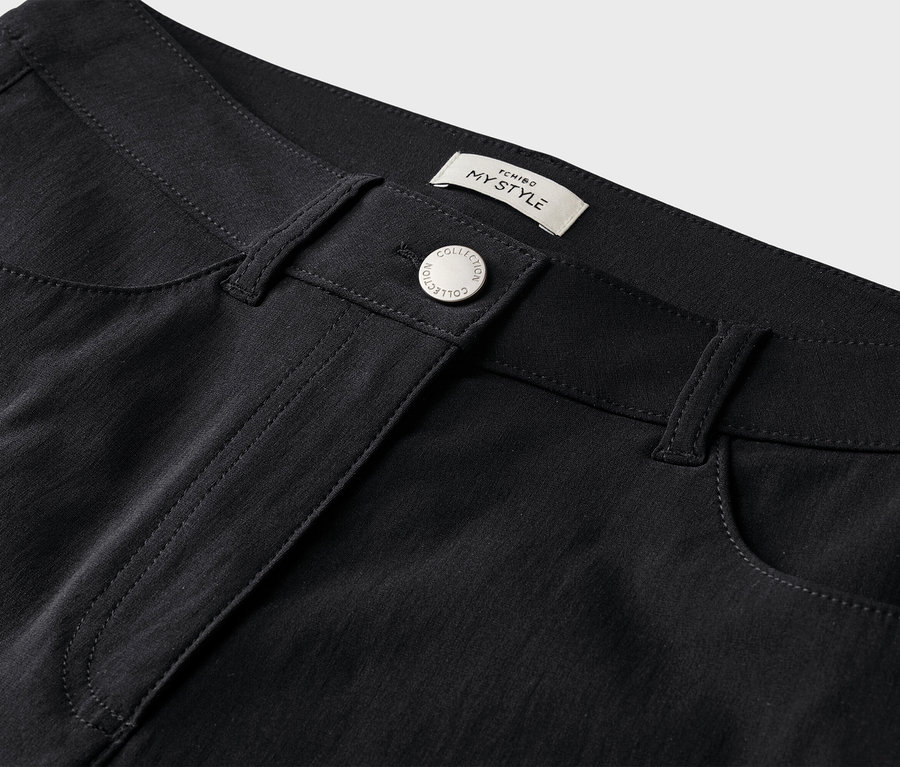 Gros plan d'un pantalon noir avec bouton et poches.