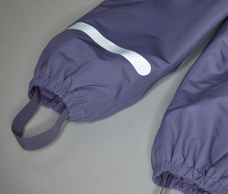 Gros plan du bas d'un pantalon violet avec élastique à la cheville et détail réfléchissant.