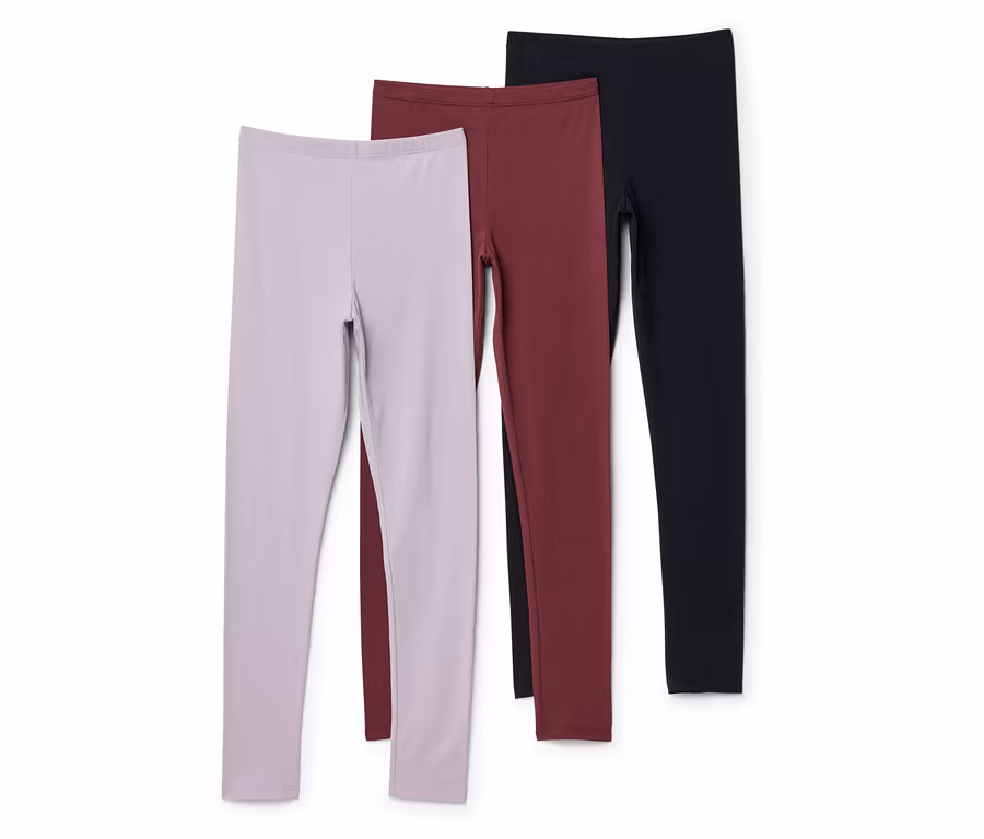 Trois leggings lilas, bordeaux et noirs sont superposés sur un fond blanc.