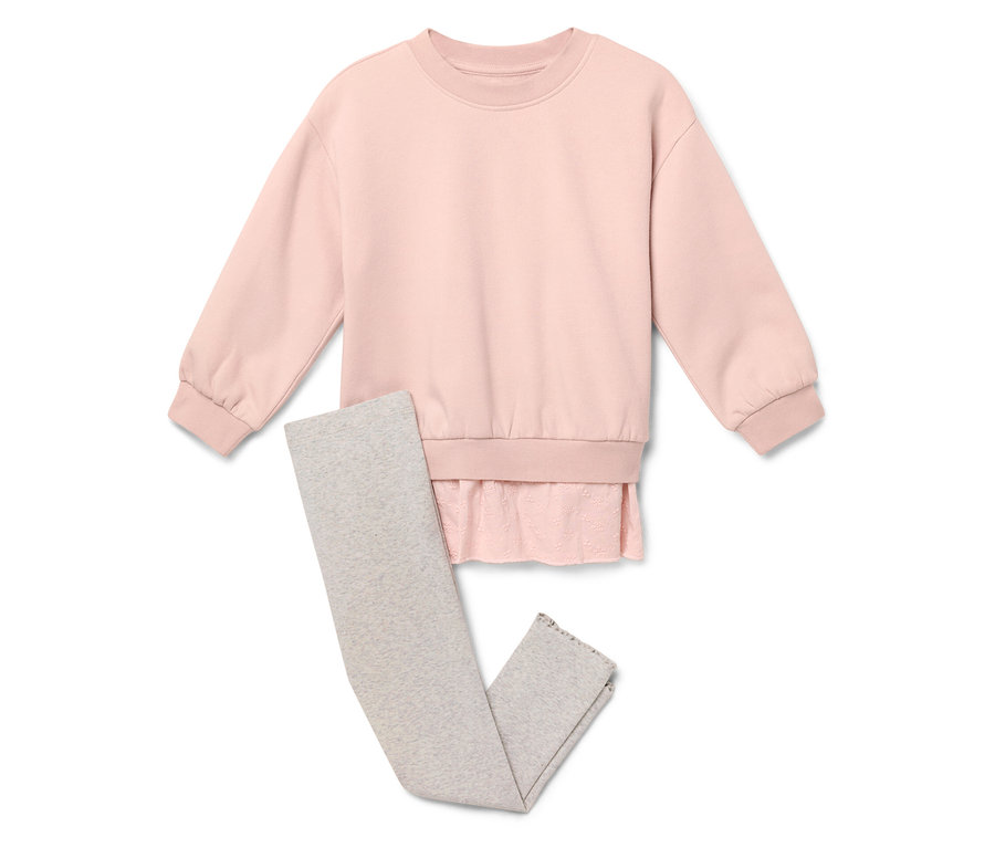 Un pull rose est placé à côté d'un legging gris.