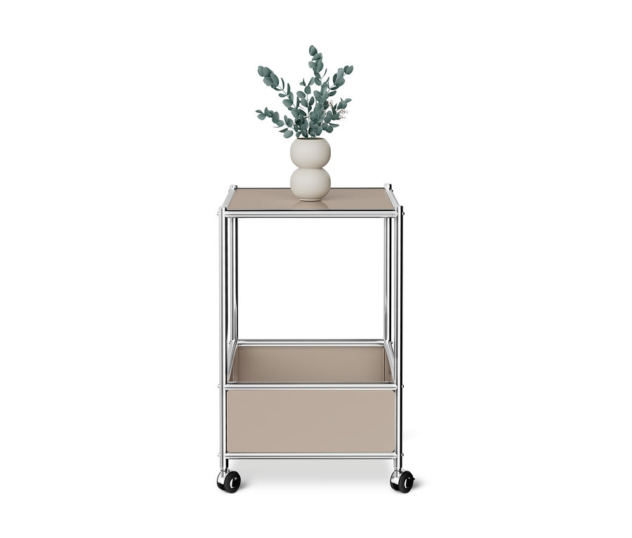 Table basse en métal « CN3 » taupe sur roulettes avec deux niveaux, sur le dessus un vase blanc avec des feuilles vertes.