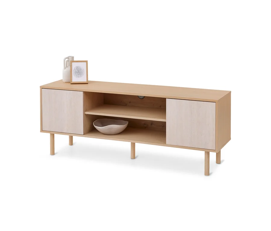 Meuble TV en bois clair avec deux étagères ouvertes, deux portes fermées et six pieds. Dessus, un vase blanc, un cadre en bois et un bol.