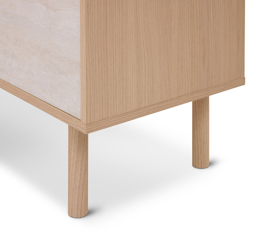 Coin inférieur d'une armoire en bois de chêne clair avec deux pieds ronds en bois et un panneau en pierre beige clair, sur fond blanc.