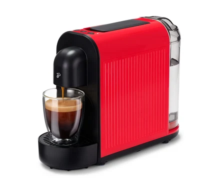 L'espresso coule dans un verre sous une Cafissimo now rouge.