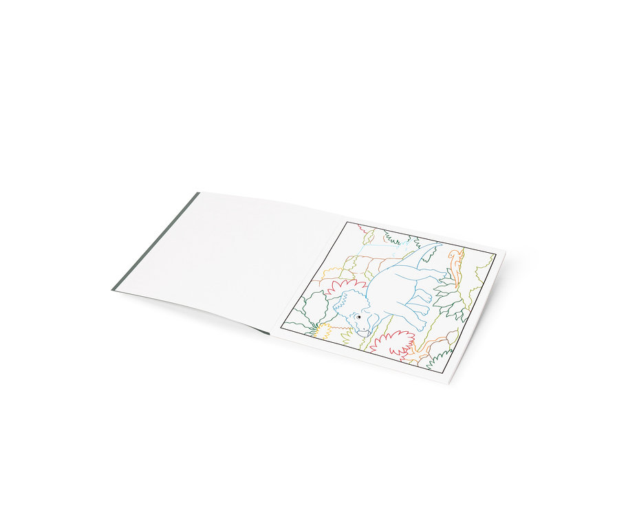 Livre de coloriage ouvert avec une page blanche vierge à gauche et un dessin au trait coloré d'un dinosaure entouré de plantes à droite.