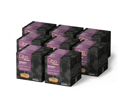 Huit paquets de capsules Qbo by Tchibo Espresso ORO LATINO, de couleur violet foncé, contenant 216 capsules au total, avec une intensité de 7/10, sont empilés.