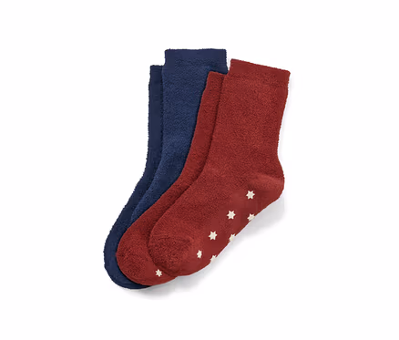 Deux paires de chaussettes moelleuses pour enfant, une bleu foncé et une bordeaux avec des étoiles blanches.