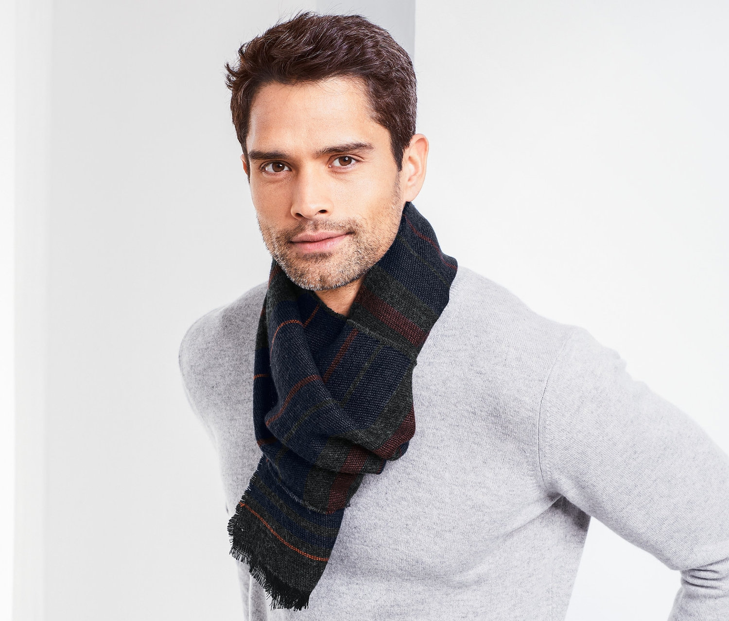 Un homme pose avec une écharpe tissée.