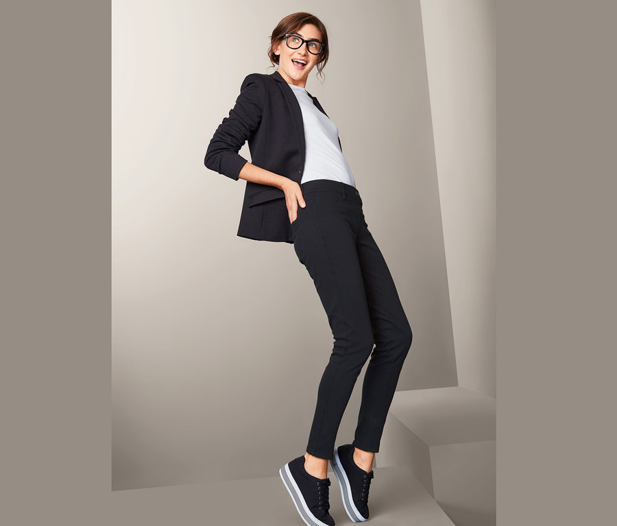 Femme posant en veste noire et jegging.