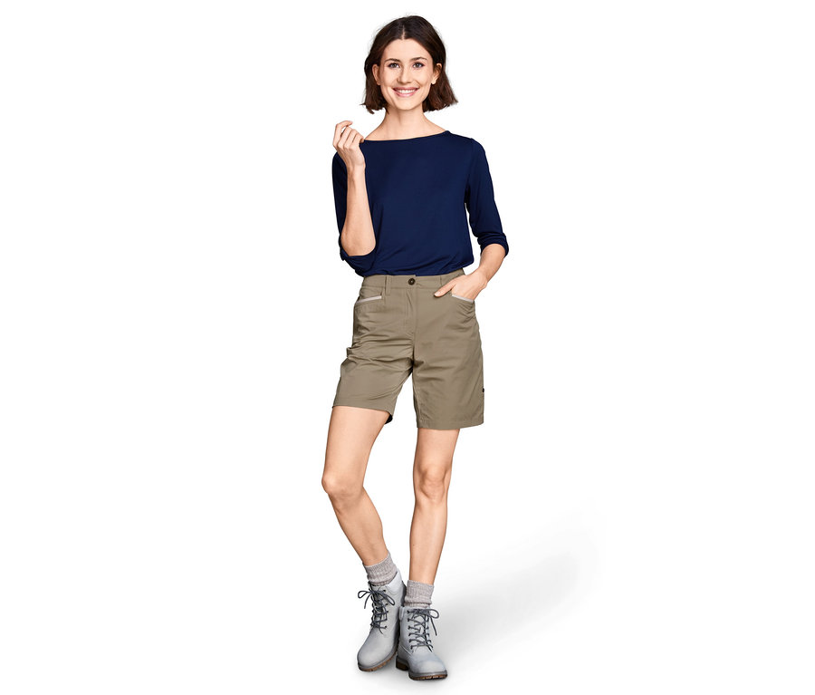 Femme posant en short fonctionnel softshell et haut bleu.