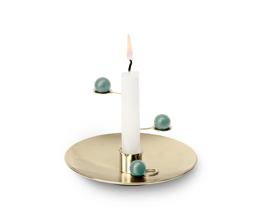 Une bougie de méditation allumée sur un bougeoir doré avec des détails turquoise.