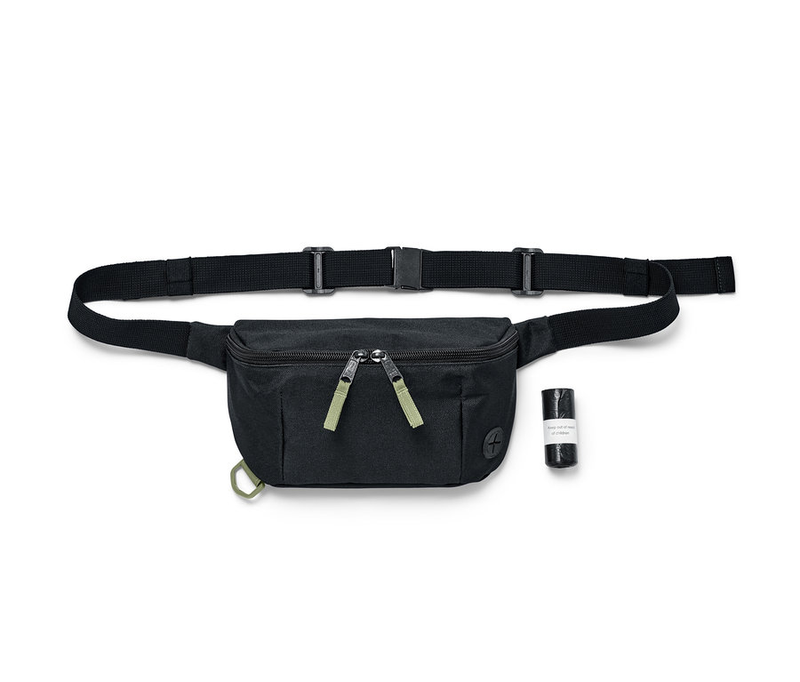Sac de promenade pour chien noir avec une ceinture noire et un rouleau noir de sacs à excréments pour chien sur un fond blanc.
