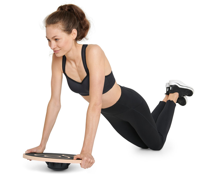 Femme faisant des pompes sur un plateau d’équilibre.