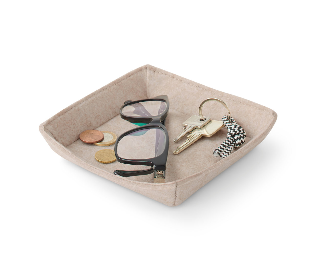 Des pièces de monnaie, des lunettes et des clés sont posées dans une coque en feutre beige.