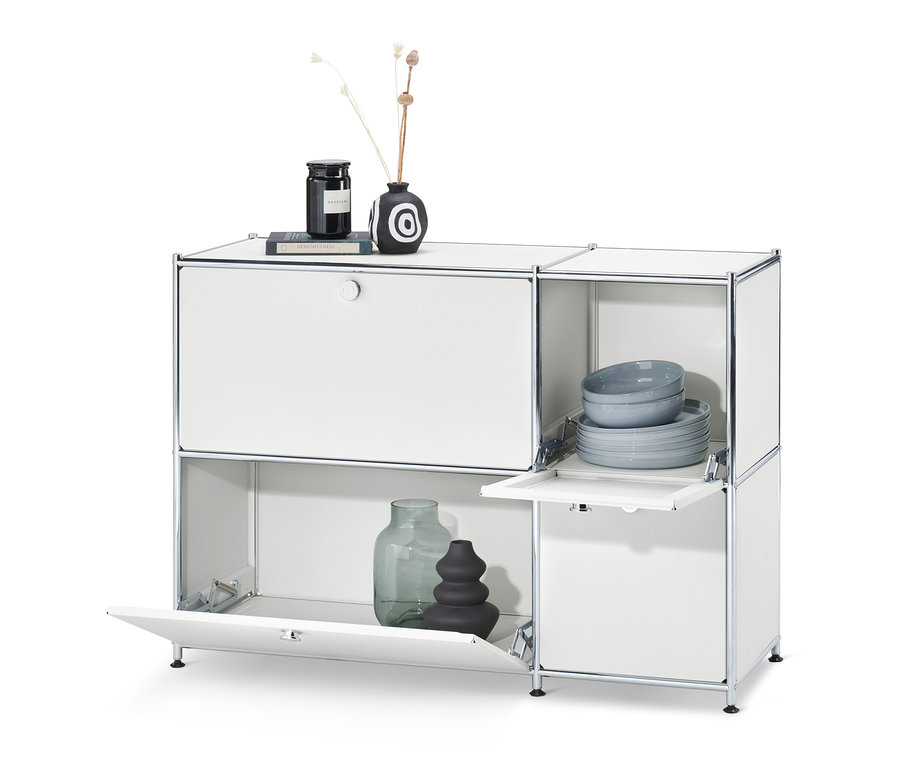 Buffet bas « CN3 » blanc avec 4 abattants. Sur le dessus, vase et bougie, à l'intérieur, assiettes et bols.