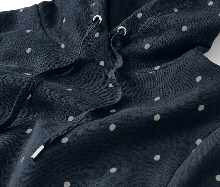 Gros plan sur une robe d’intérieur bleu marine à capuche et à pois blancs.