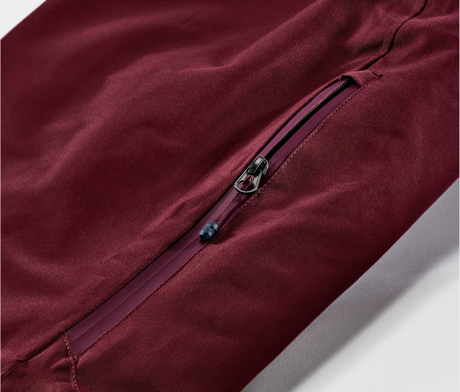 Détail d'un pantalon de ski et de snowboard bordeaux avec une fermeture éclair.
