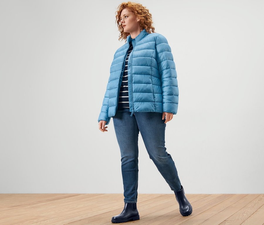 Une femme portant une veste matelassée, un t-shirt manches 3/4 à rayures et un tregging « Fit Nelly ».