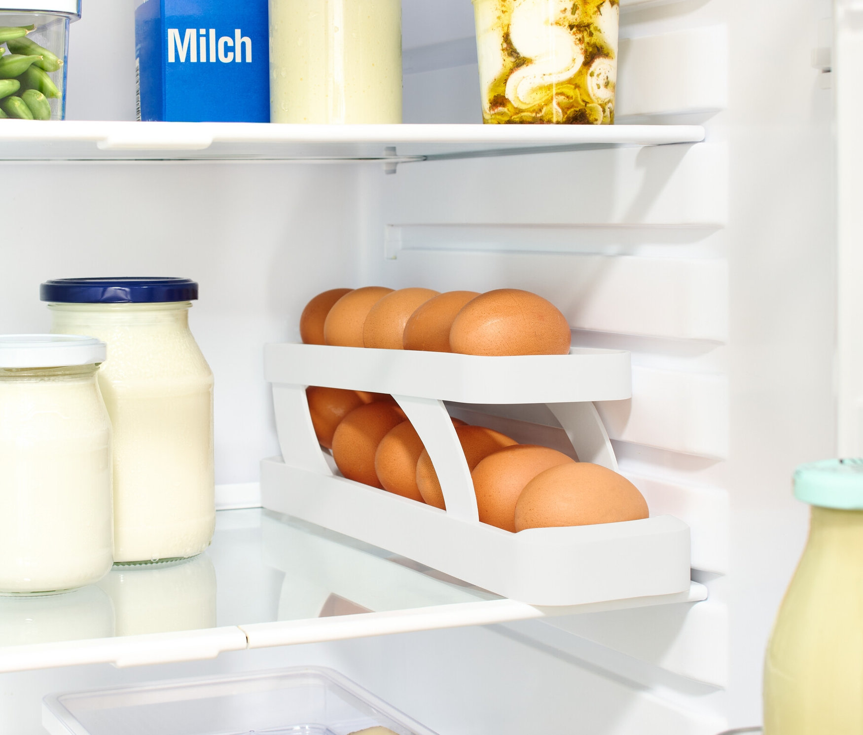 Dans le réfrigérateur, il y a du lait, des verres et une Conservation des œufs.