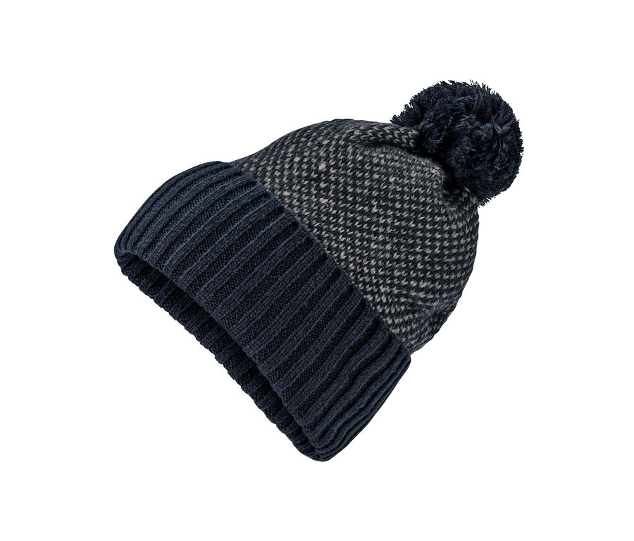 Gros plan d'un bonnet en maille bleu marine et beige avec pompon sur fond blanc.