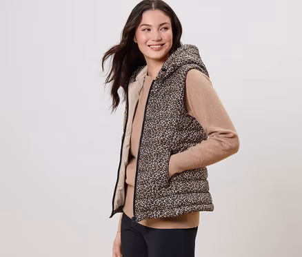 Femme posant dans un gilet sans manche matelassé imprimé à capuche.