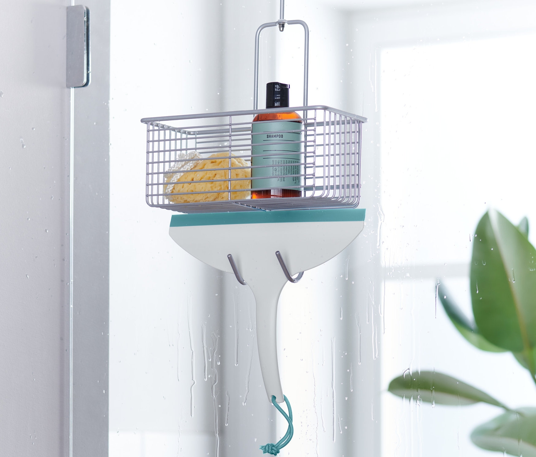 Une raclette de salle de bain est suspendue à une porte de douche.